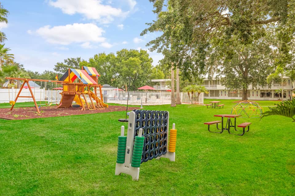 Community playground and recreation area with play structures, games, and picnic tables