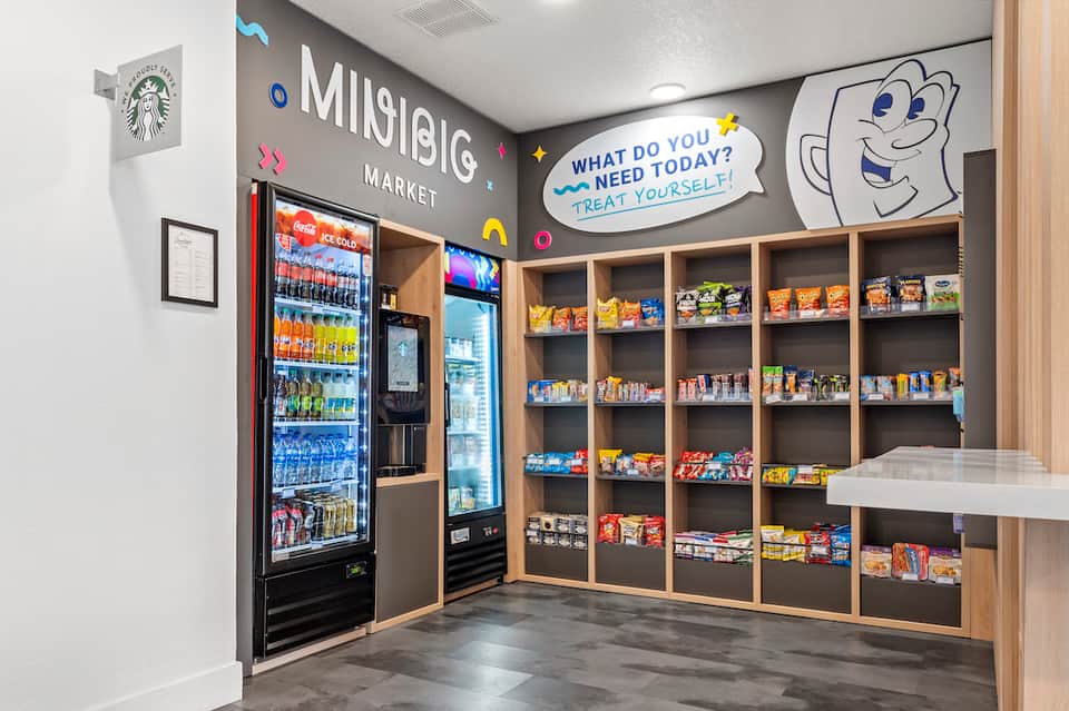 Hotel market convenience store with vending machine, shelving, and playful cartoon signage