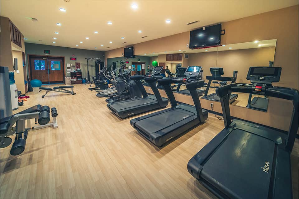 Fitness center with multiple treadmills, ellipticals, and exercise equipment