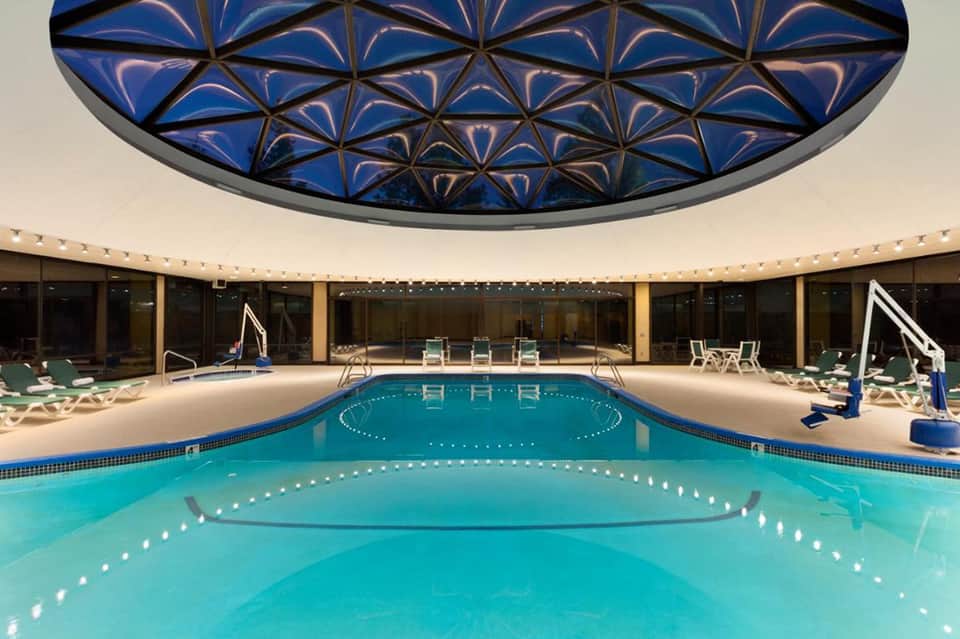 Indoor swimming pool with geometric patterned blue ceiling dome and clean lane markings