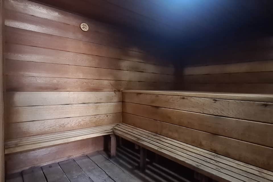 Interior of wooden sauna with tiered benches and warm wood paneling