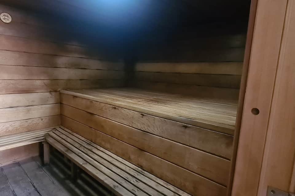 Interior view of wooden sauna with tiered benches and dim lighting