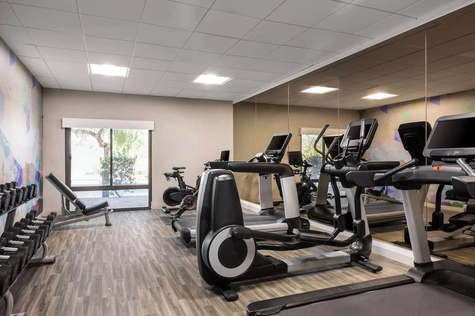 Fitness center with cardio equipment, exercise bikes, treadmills, and large windows