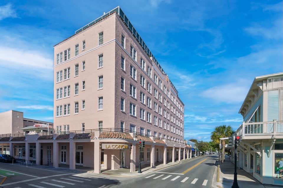 Historic multi-story hotel building with cream and brick facade, ground floor retail, street view