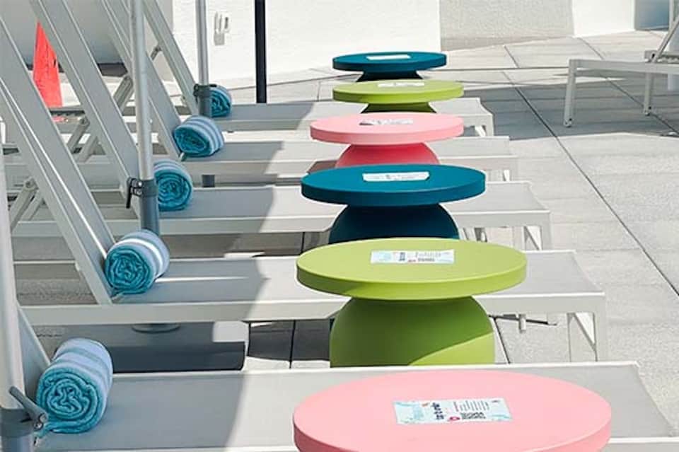 Rooftop lounge chairs with colorful round cushions in pastel tones arranged in rows