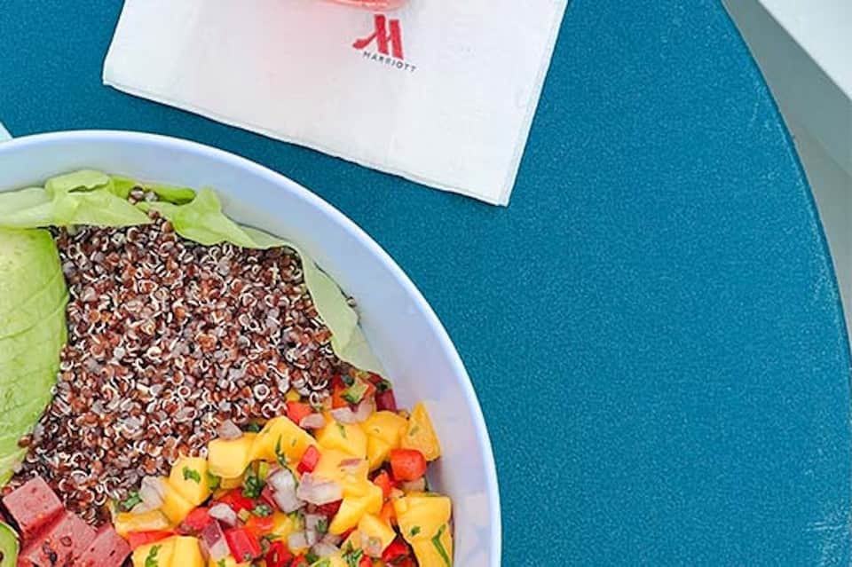 Healthy salad bowl with quinoa and vegetables by Marriott poolside