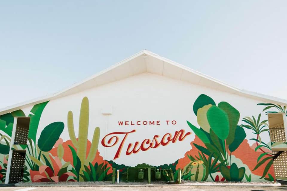 Welcome to Tucson mural on tent structure with desert plant illustrations in vibrant colors