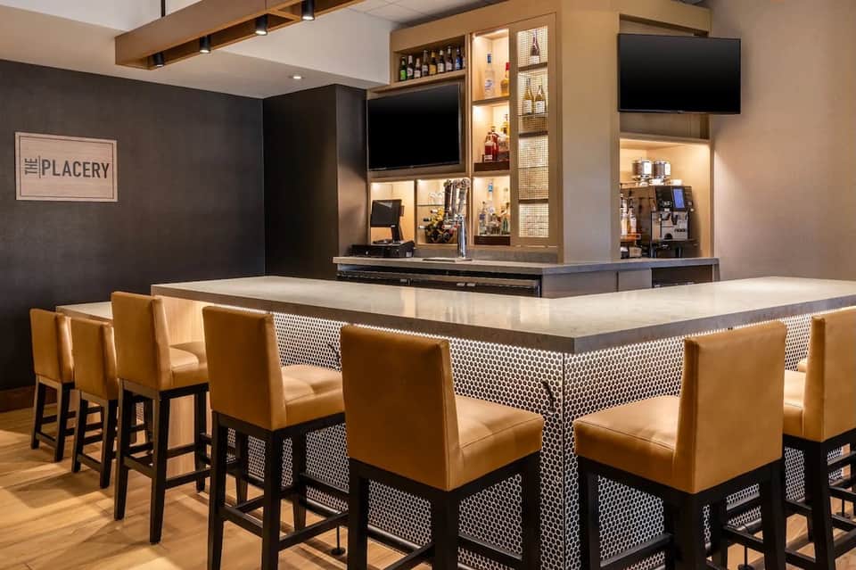 Hotel bar lounge with polka dot counter detail, amber leather seating, and backlit liquor display