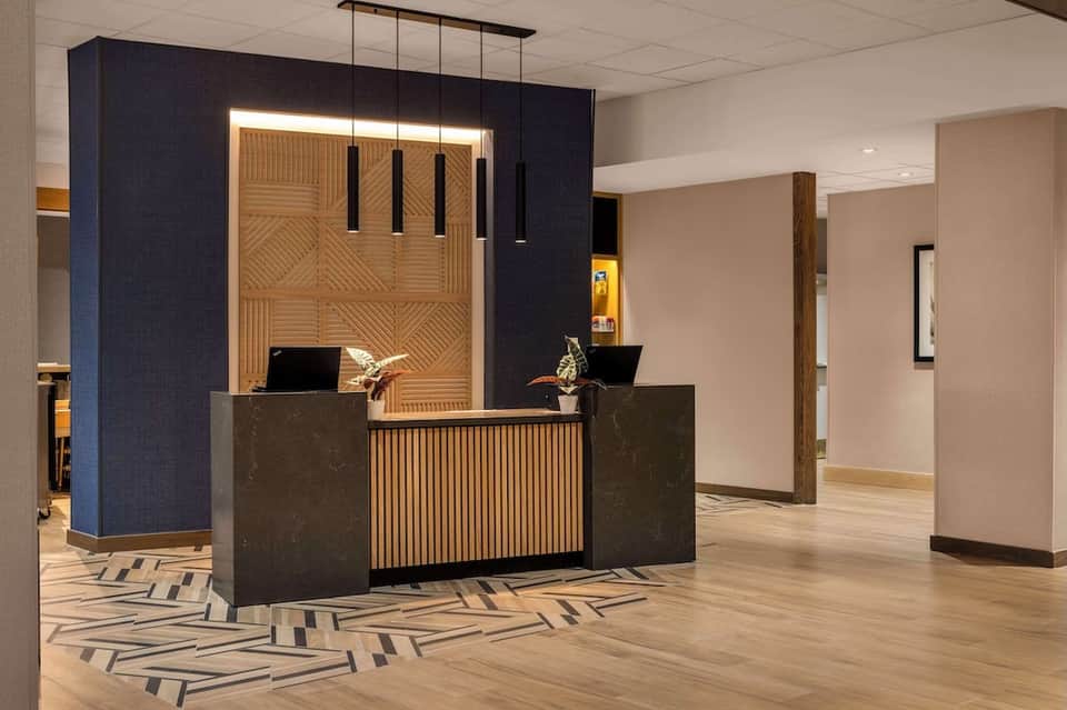 Contemporary hotel reception desk with wooden accent wall and blue panel