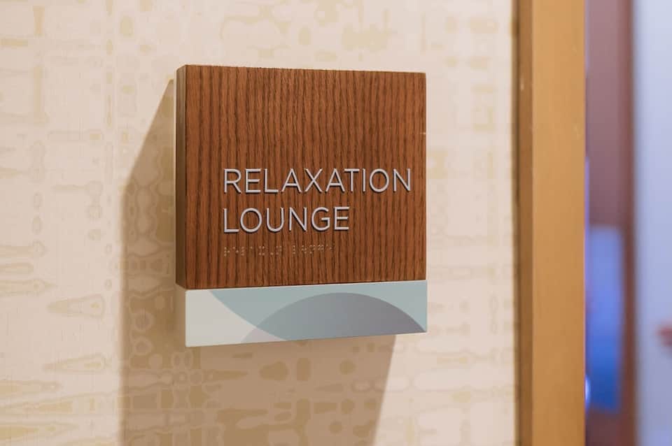 Wooden signage for Relaxation Lounge on beige hallway wall