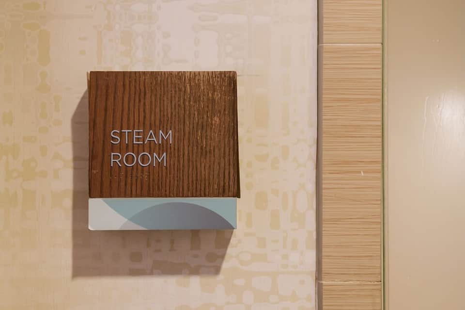 Steam room wooden sign on corridor wall at spa facility