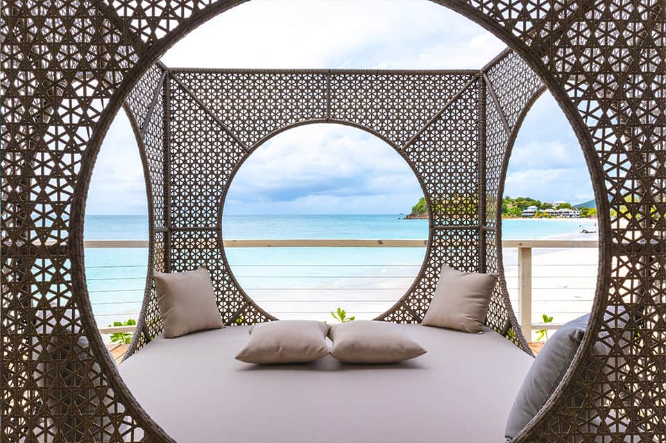 Decorative circular bed canopy with ocean and beach view through latticed frame