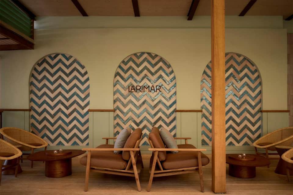 Spa lounge with chevron pattern wall panels, wooden beams, modern chairs, and LARIMAR branding