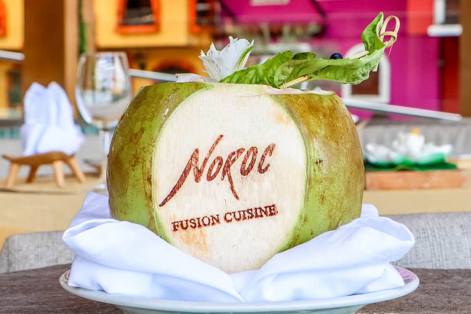 Decorative coconut carved with Noroa Fusion Cuisine restaurant logo