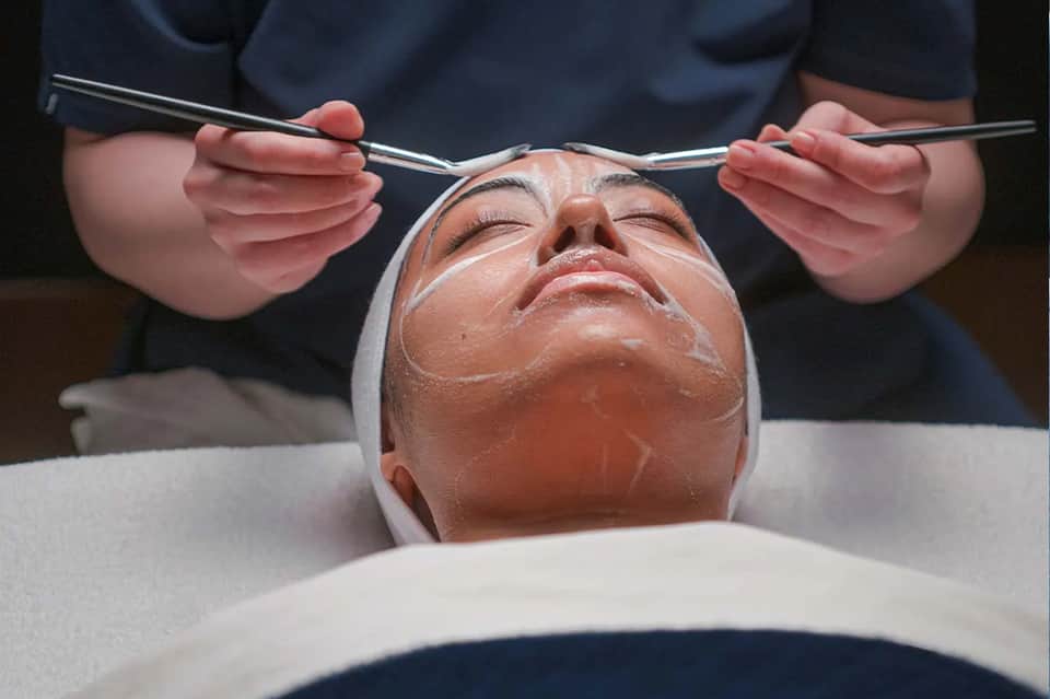 Spa facial treatment with aesthetician applying product to client's face