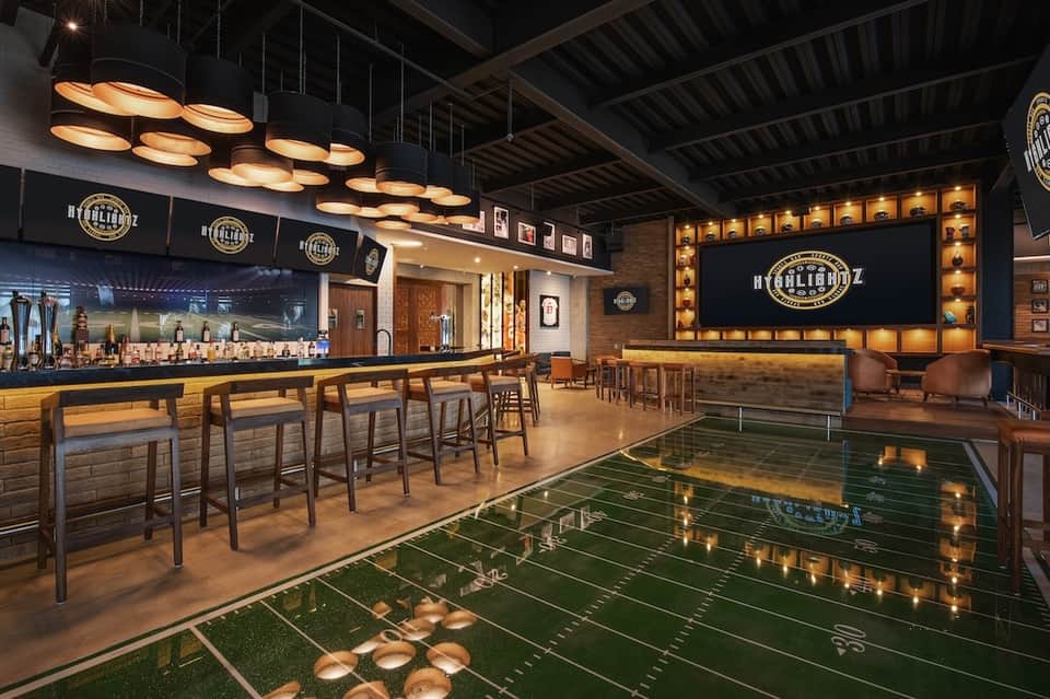 Upscale bar lounge with foosball table, ambient lighting, and bourbon-themed signage and décor