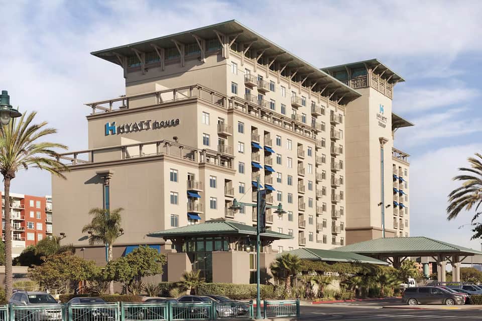Hyatt House hotel exterior with tan and brown facade surrounded by palm trees