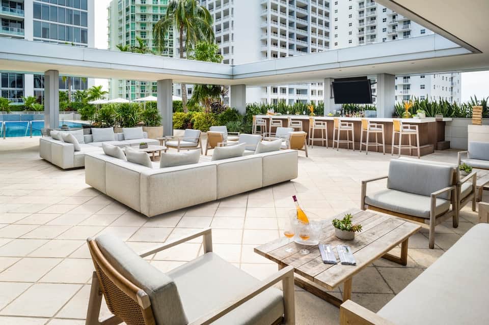 Multi-level resort terrace with lounge seating, bar counter, and swimming pool