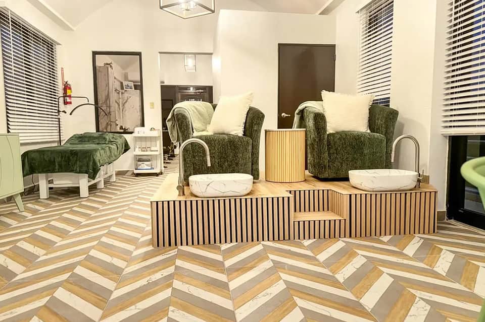 Modern pet amenity lounge with green upholstered chairs and herringbone wood flooring