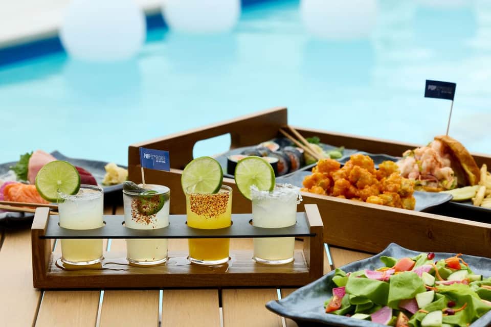 Poolside dining setup with cocktails and appetizers overlooking swimming pool