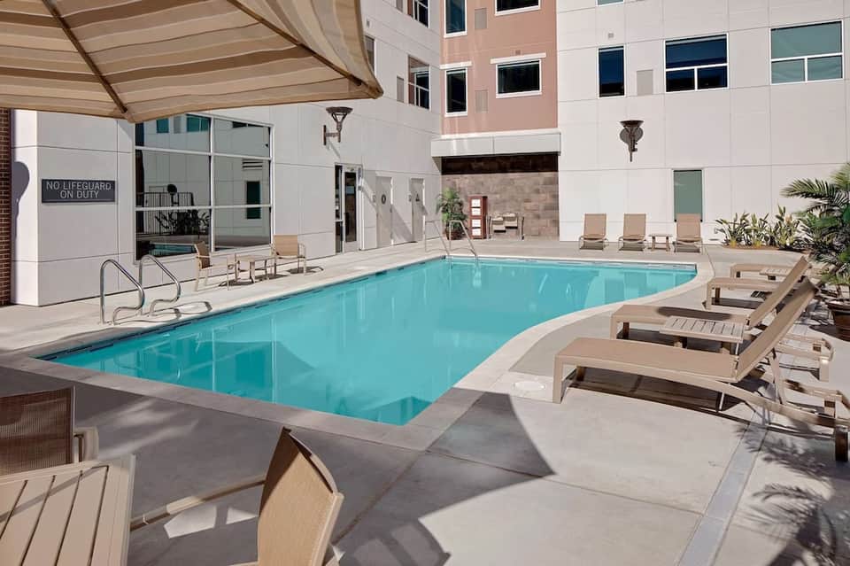 Rectangular indoor pool with beige lounge chairs and contemporary hotel architecture