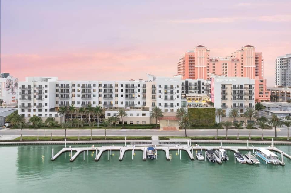Waterfront resort with marina dock, boats, and sunset sky at dusk