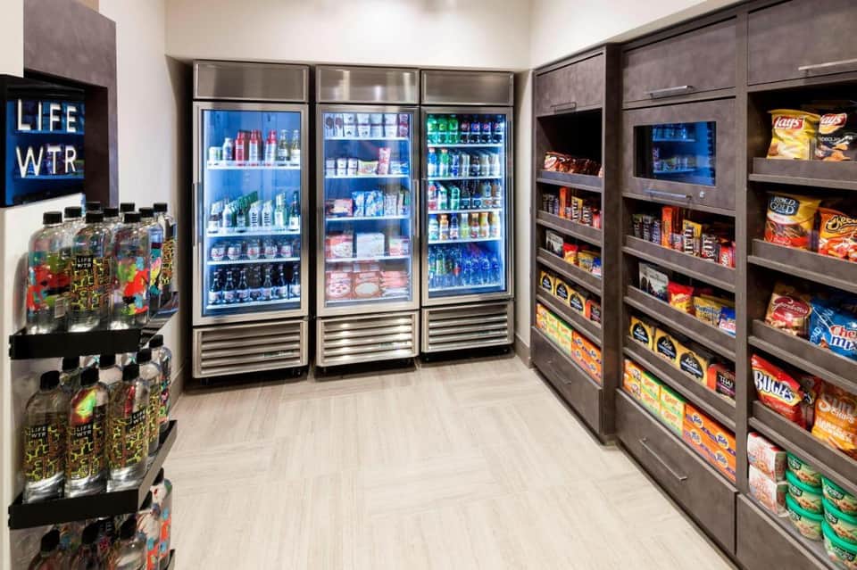 Convenience store with refrigerated beverage cases and snack shelves stocked with drinks and snacks