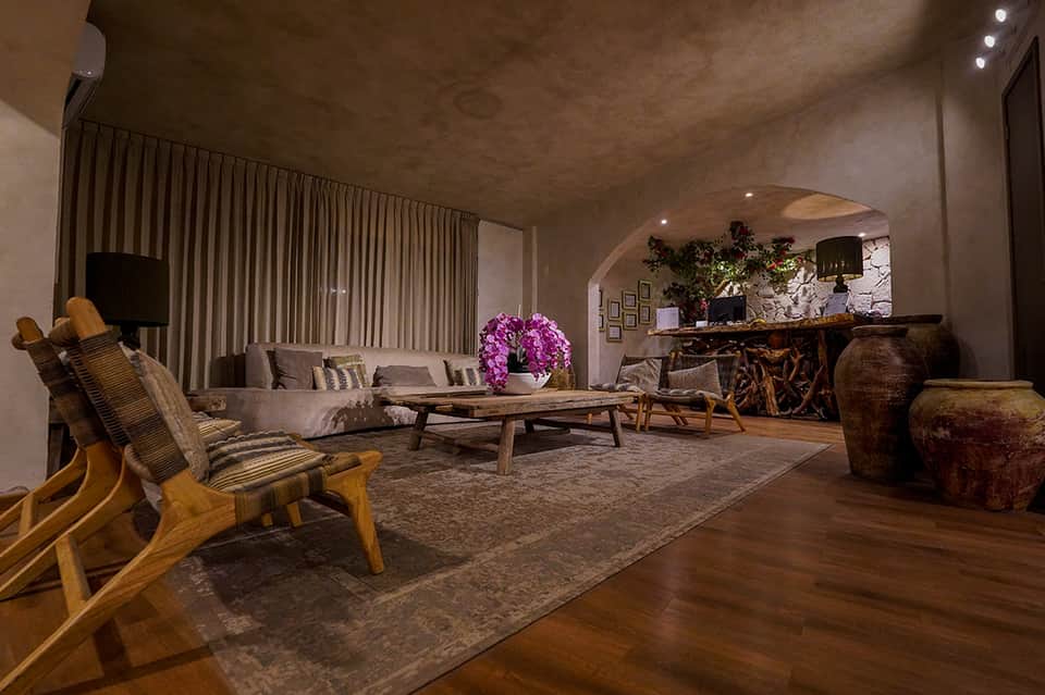 Luxury lounge area with wooden chairs, fireplace, and purple flower arrangement