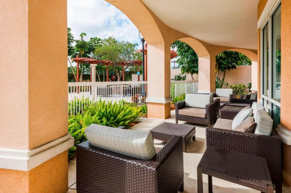 Covered patio seating area with rattan furniture and mountain landscape views