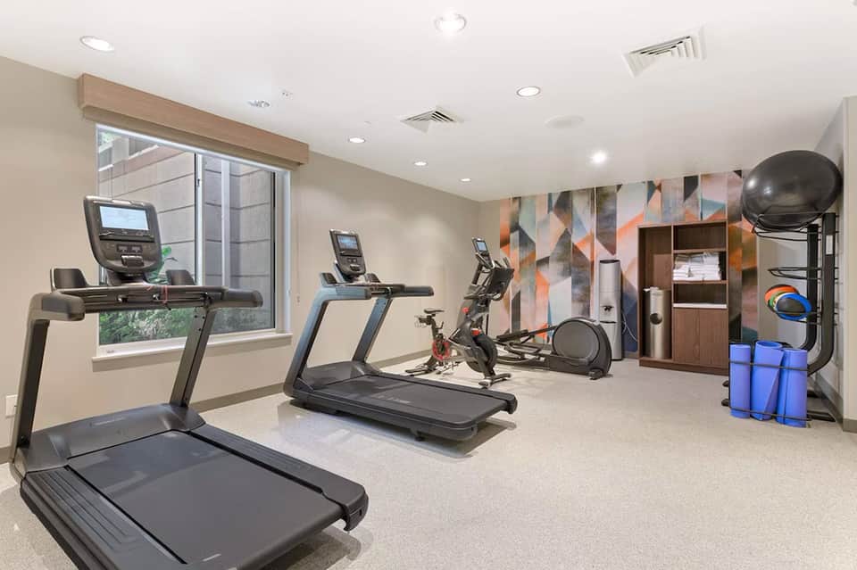 Fitness center with treadmills, exercise bike, and geometric wall artwork