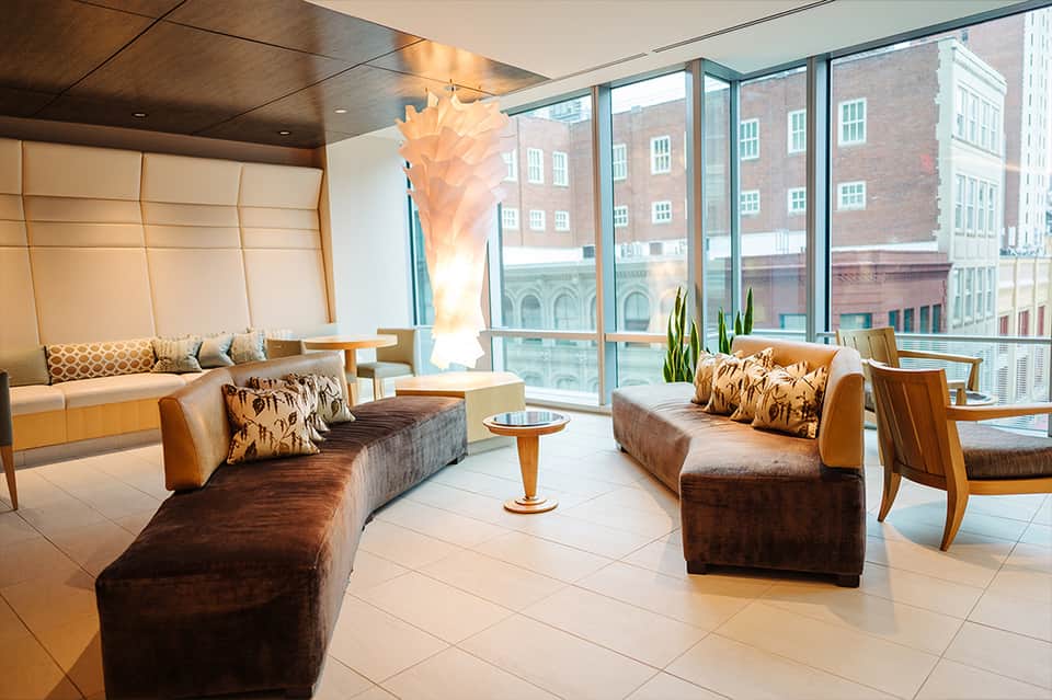 Luxury high-rise hotel lounge with floor-to-ceiling windows, modern furniture, and city skyline views