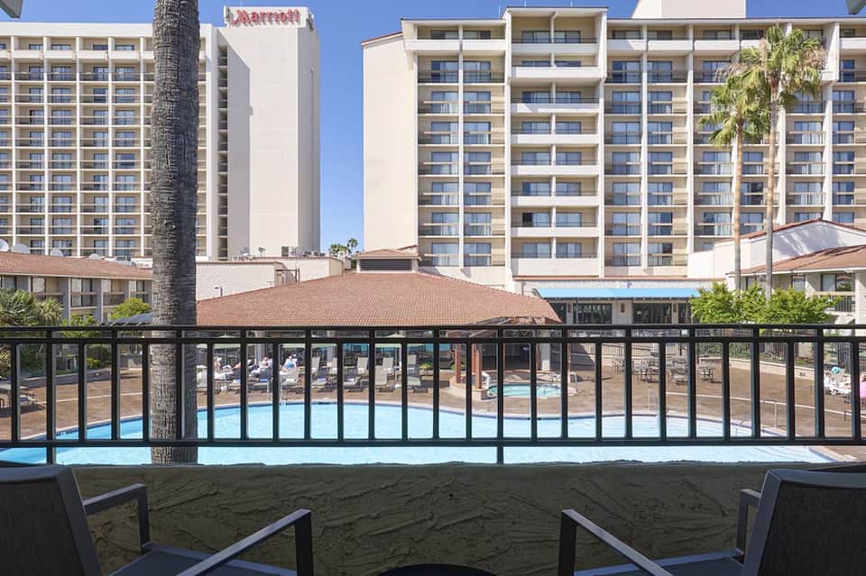 Beachfront Marriott resort viewed from sand with multi-story building and pool visible