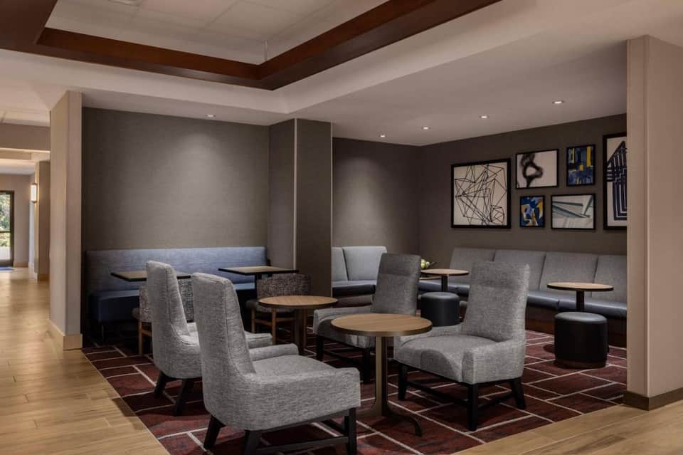 Upscale lounge area with built-in seating, abstract wall art, wooden accents, and neutral color palette