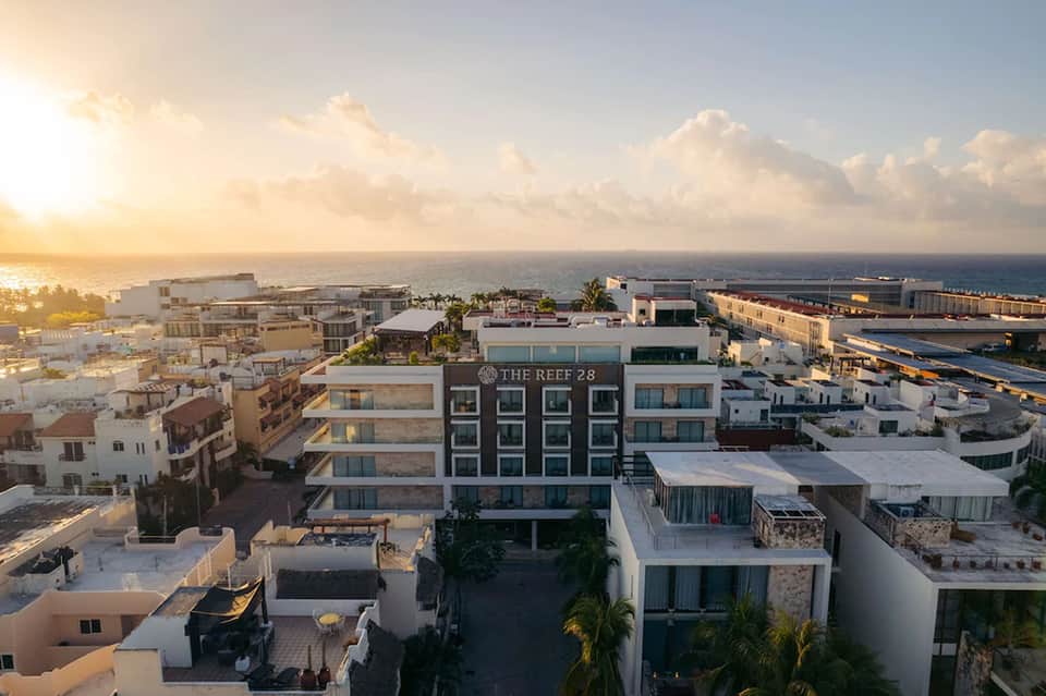 Coastal resort building overlooking ocean at golden hour with nearby commercial port