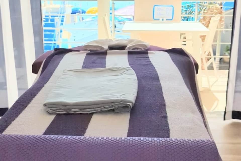 Beachfront bedroom with ocean view, purple and white striped bedding and balcony