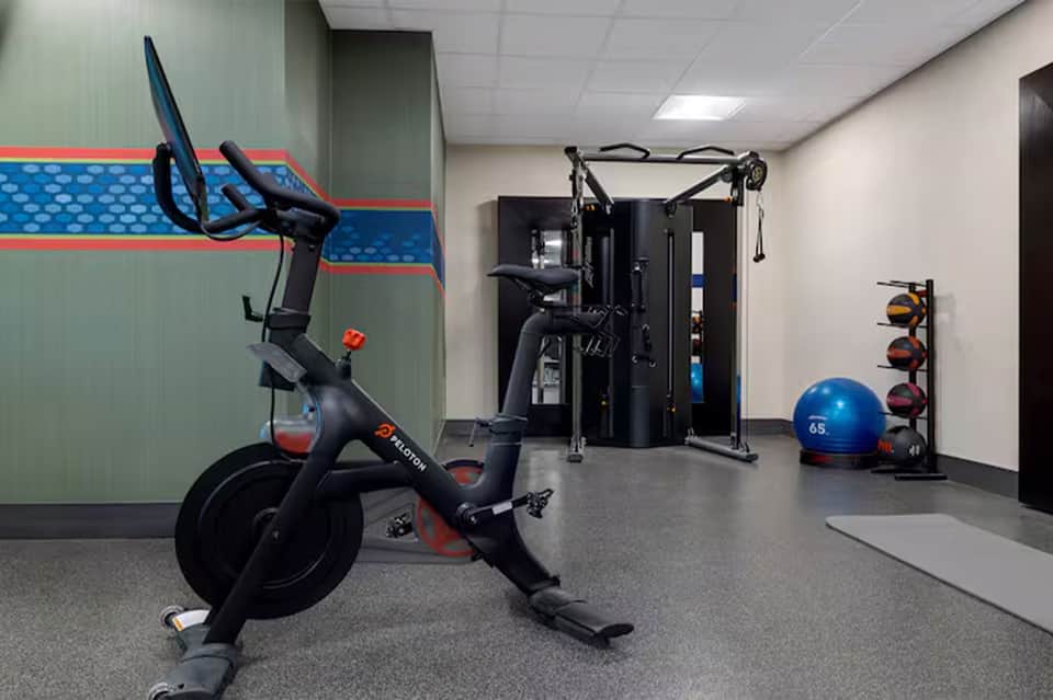 Modern fitness center with exercise equipment including stationary bikes and strength machines