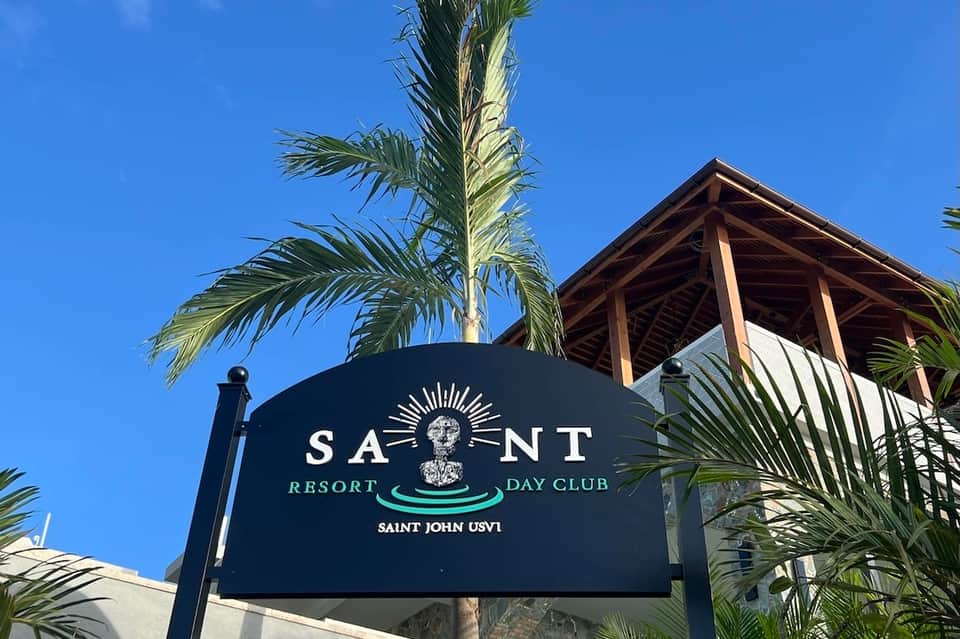 Saint Resort Day Club entrance sign with palm trees and wooden structure in Caribbean setting