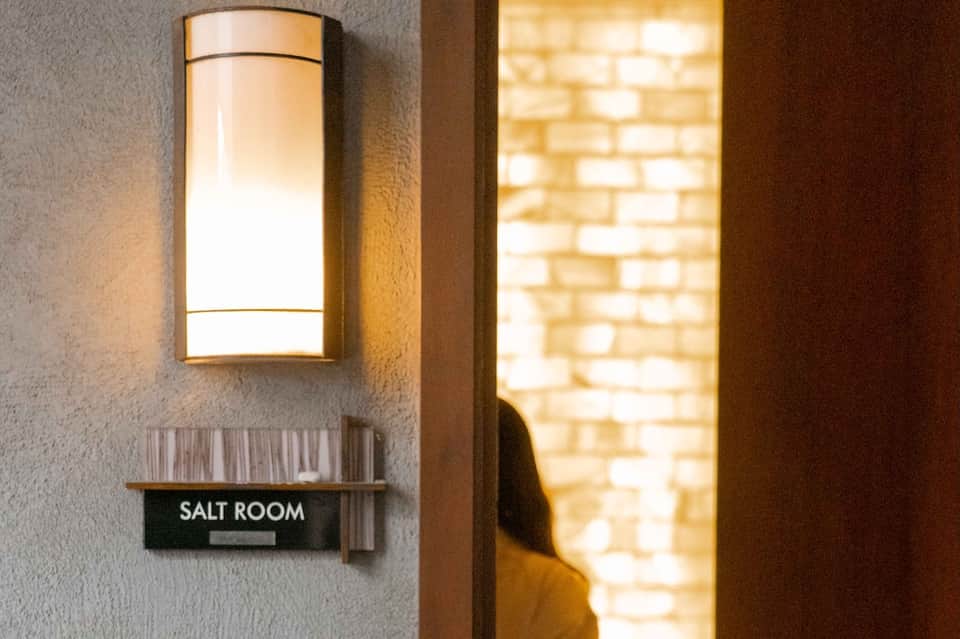 Salt Room entrance with illuminated wall sconce and warm brick interior