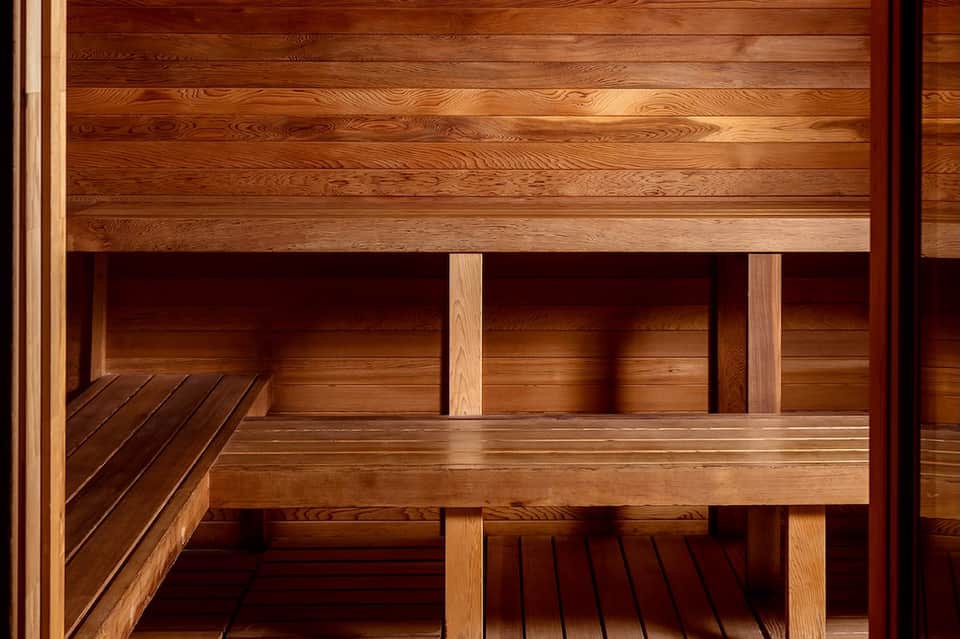 Interior view of wooden sauna with multi-level benches and warm wood construction