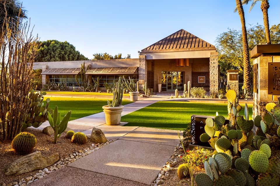 Contemporary resort entrance with desert landscaping, cacti, and manicured lawn