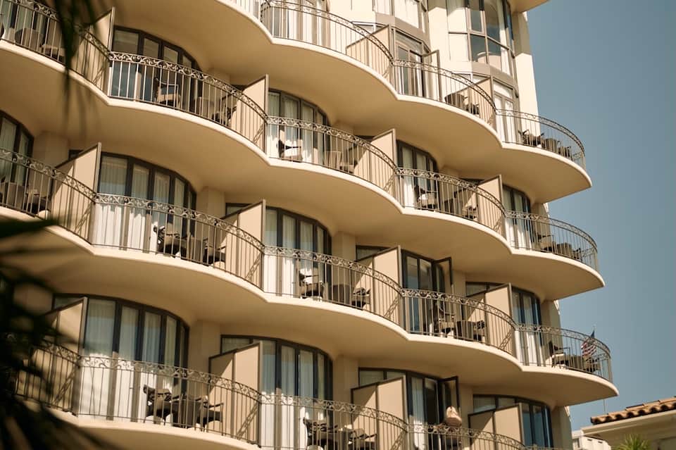 Modern curved residential building facade with multiple balconies and ocean views