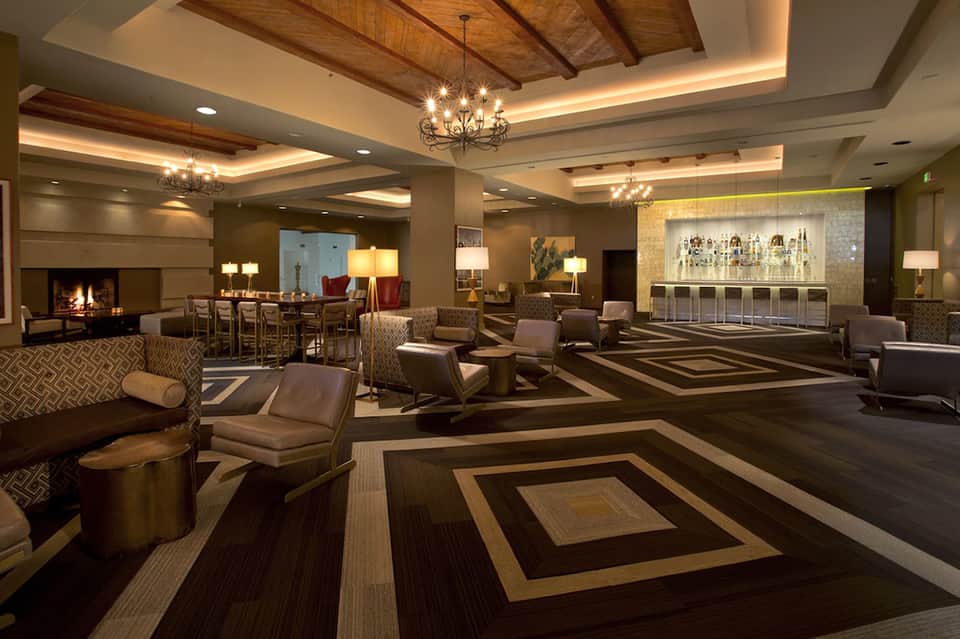 Elegant hotel lobby with fireplace, high ceilings, and bar area