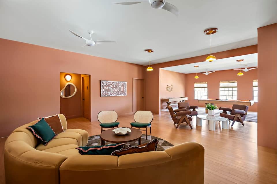 Modern living room with curved yellow sofa and warm terra cotta walls