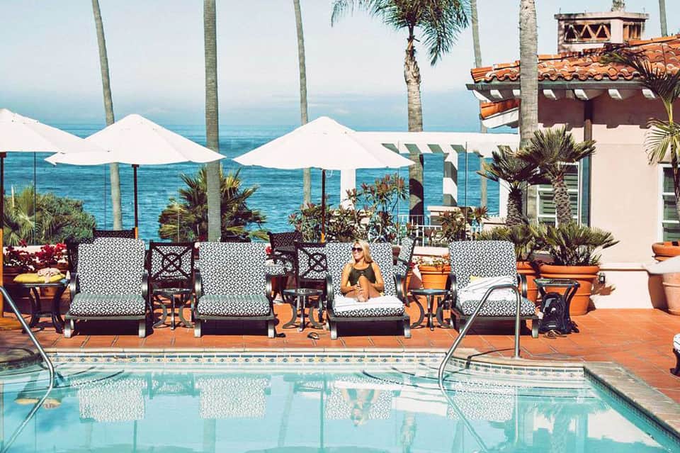 Coastal resort terrace with white umbrellas, lounge chairs, and ocean views