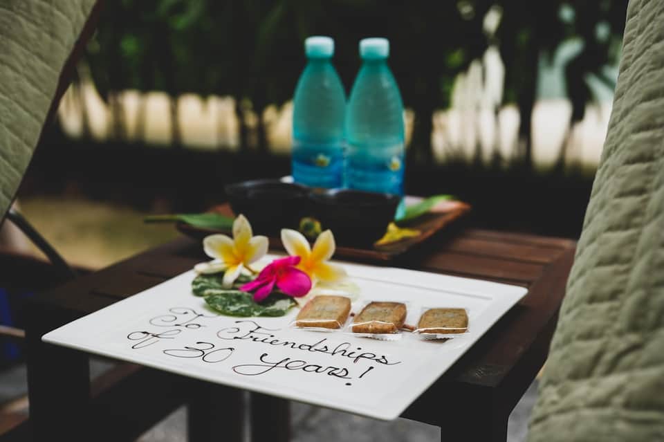 Spa treatment setup with flowers, water bottles, and anniversary celebration messaging