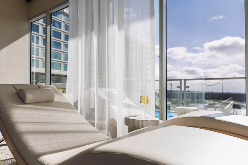 Modern spa relaxation area with lounge chairs and panoramic water views