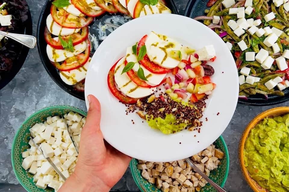 Overhead view of colorful salad plate with ingredients and prepared vegetables