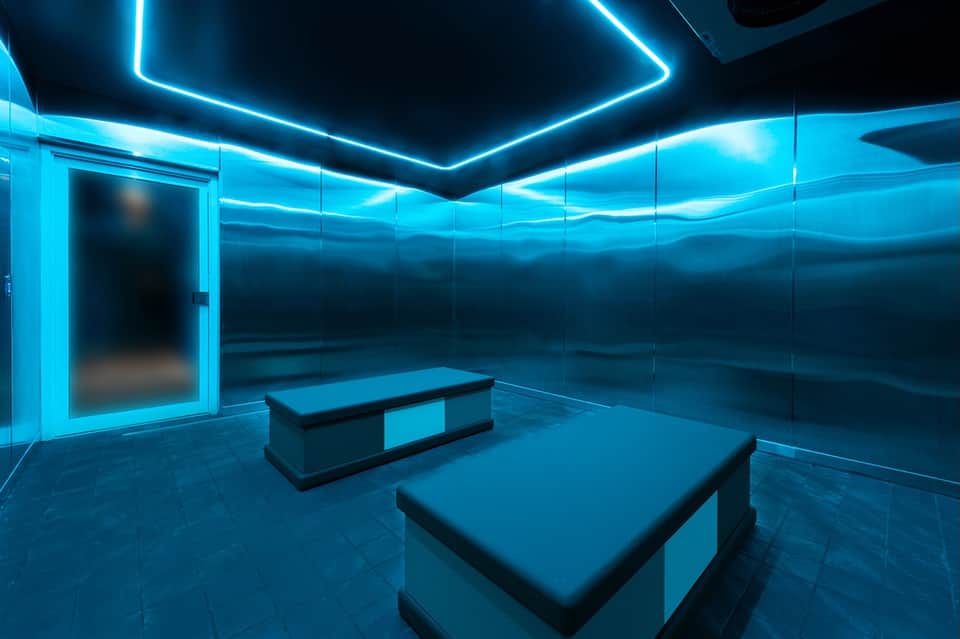 Contemporary blue neon-lit spa or wellness room with massage tables and modern minimalist design