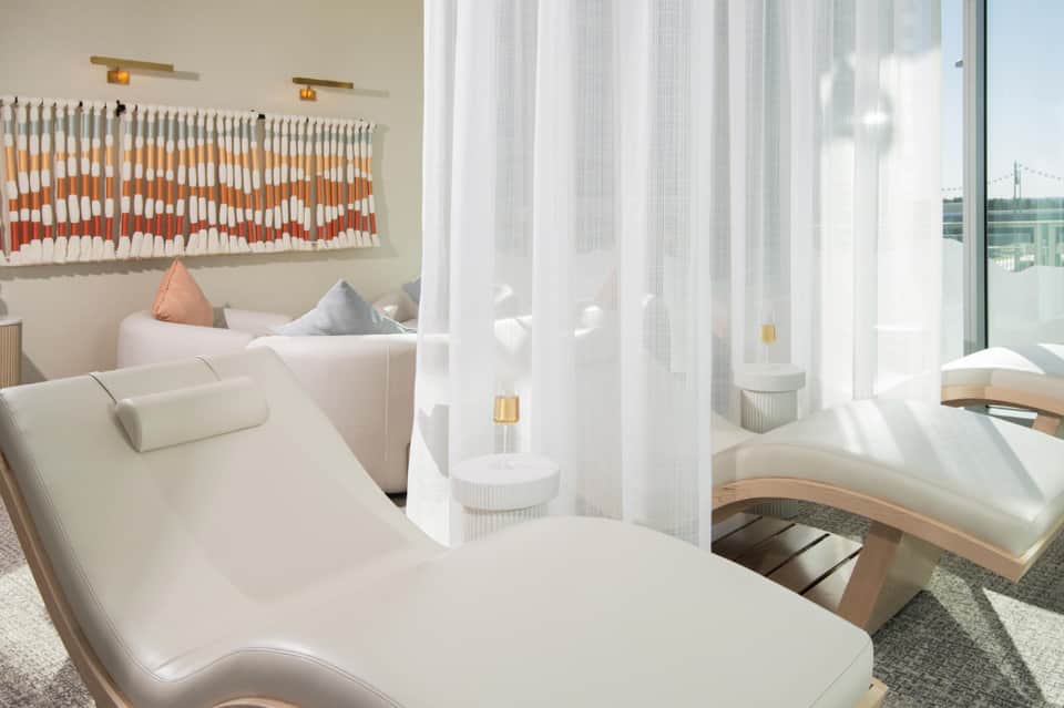 Modern spa relaxation room with white lounge chairs and floor-to-ceiling windows