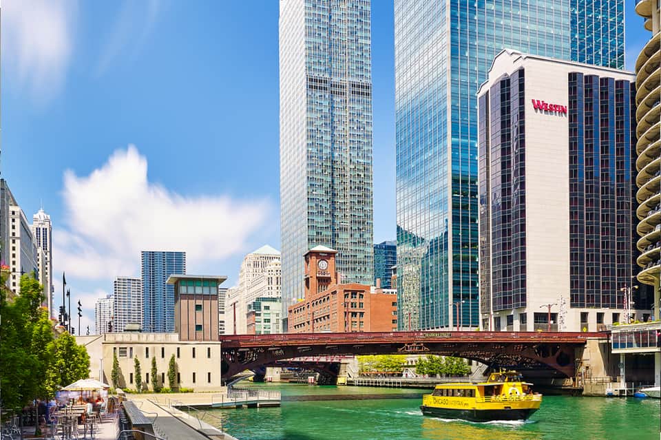 Chicago River cityscape with Westin hotel building, yellow water taxi, and downtown skyline